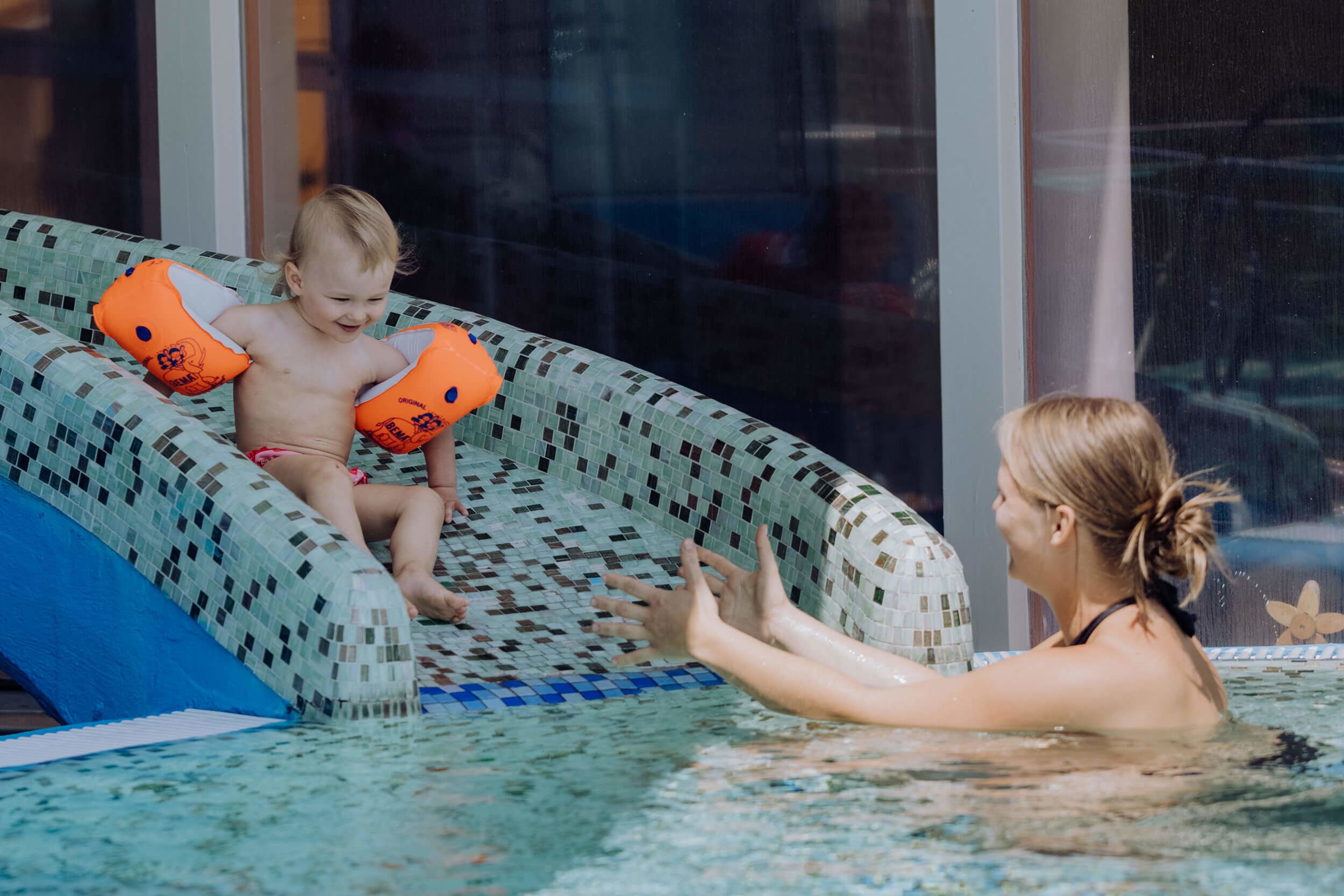 Kind beim Rutschen im Aussenpool Familienhotel Hinteregger